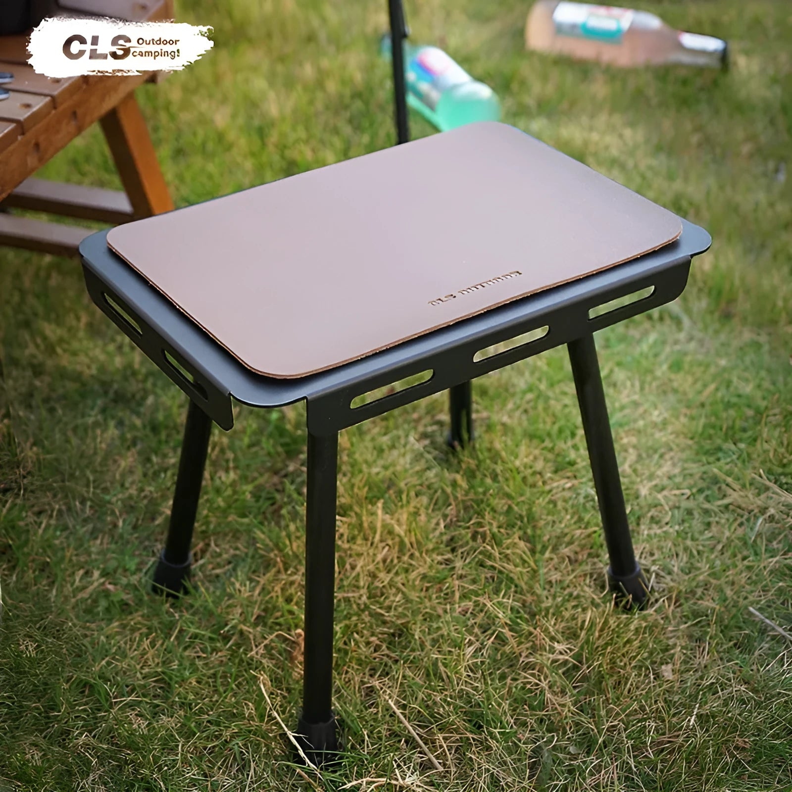 CLS aluminium folding camping stool shown in army green, converted into a small raised table next to a storage bag.