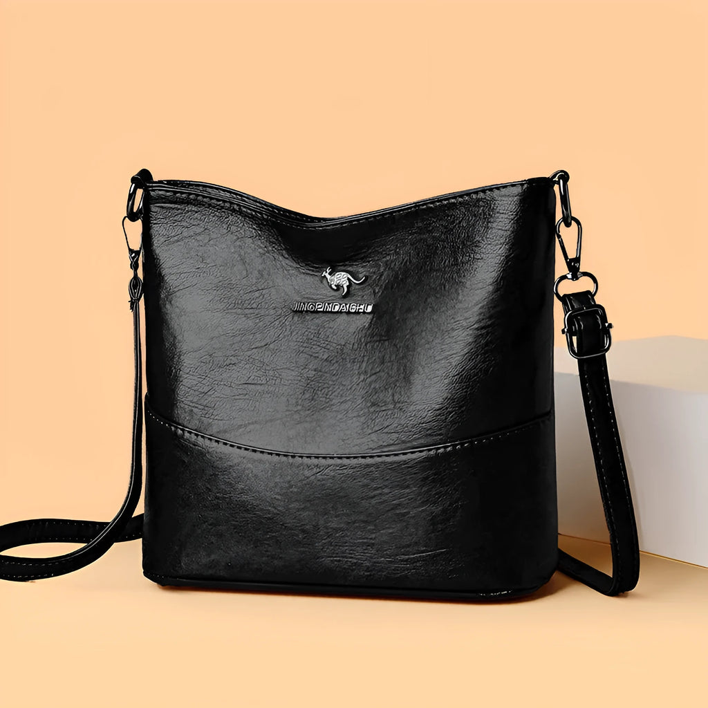 Women's soft leather bucket shoulder bag in black with minimalist design and interior phone pocket