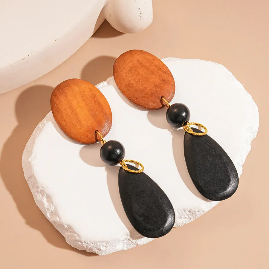 Wooden retro earrings with silver brown black colour scheme and elliptical design elements