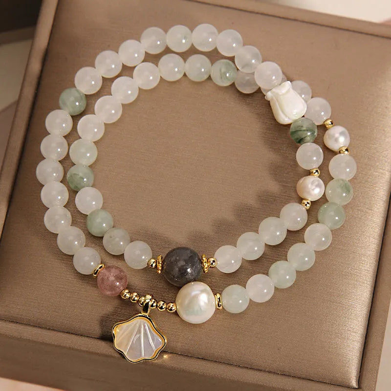 Women's crystal bracelet with a large green ginkgo leaf pendant, gold metalwork, and sparkling rhinestones.
