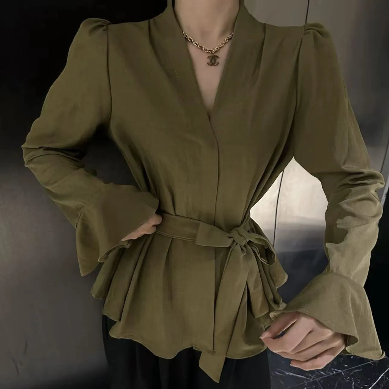 Women's black French-style shirt with irregular collar, long bell sleeves, and tied front detail.
