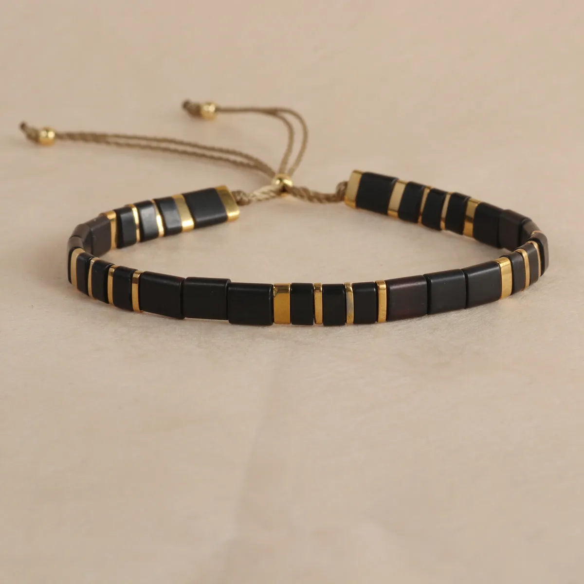 Geometric glass and coloured glaze beaded bracelet with a pull clasp in milky white colour.