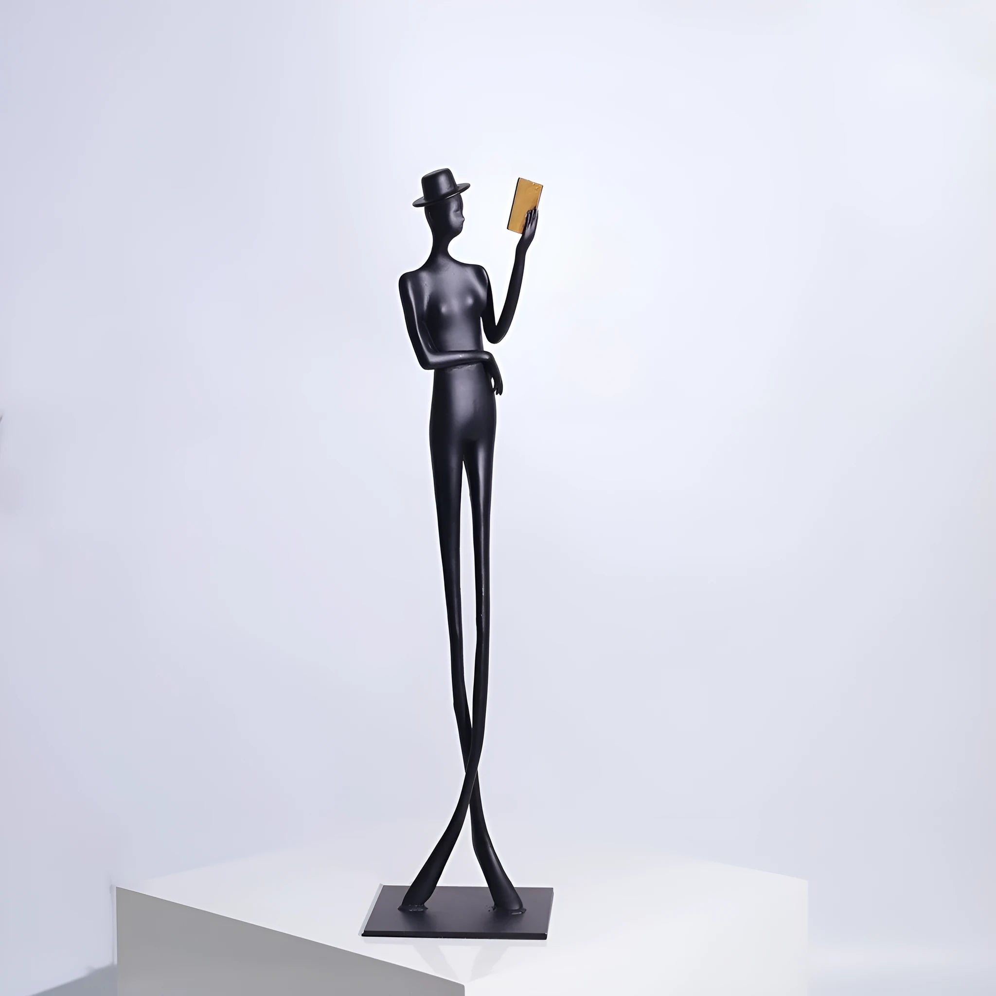 Black aluminium sculpture of reading woman for desktop decoration measuring 51cm tall