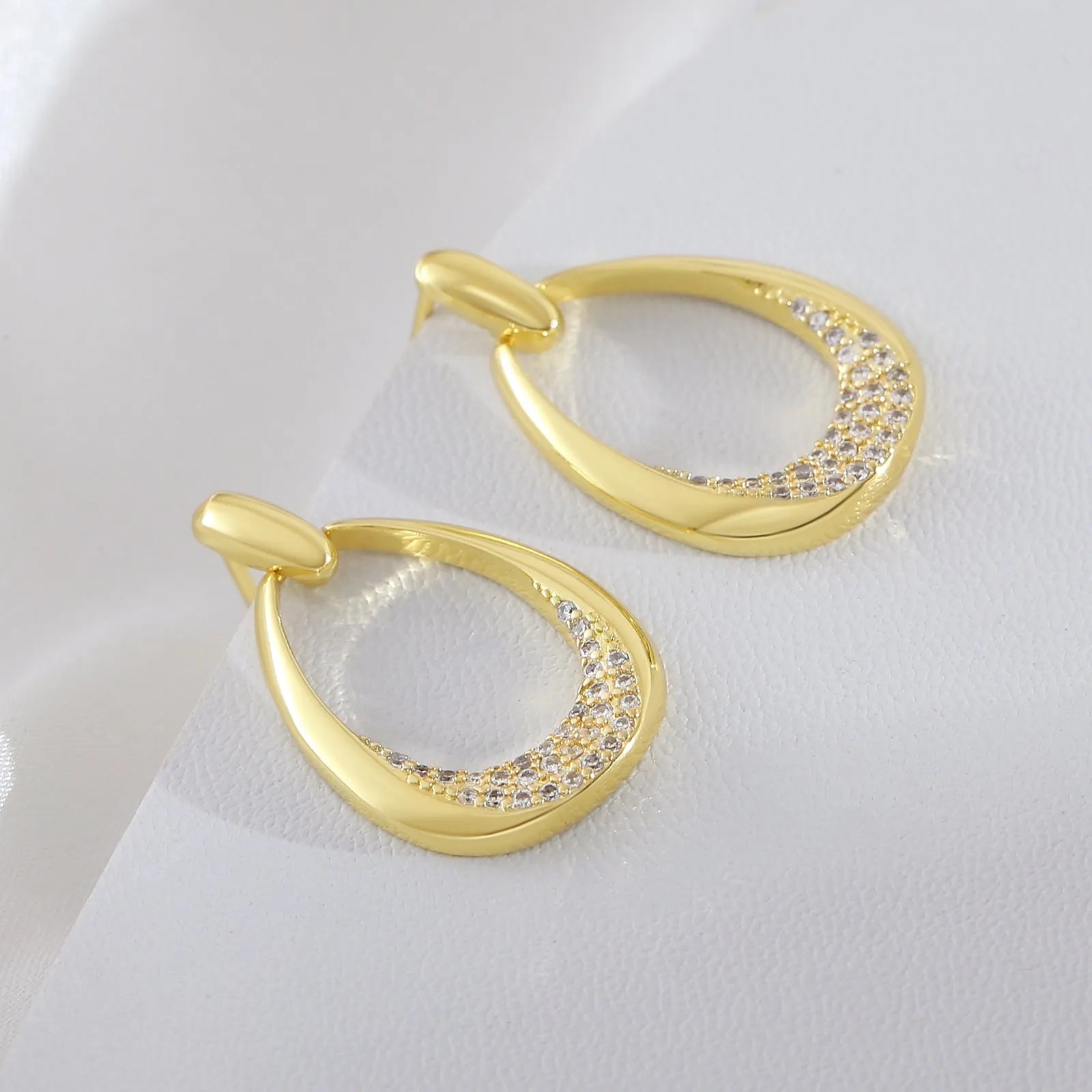 Yellow gold geometric women's drop earrings with a ring design and zircon detail on a white background.