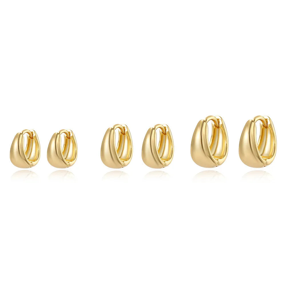 Drop-shaped copper earrings set of three sizes in gold finish on a white background