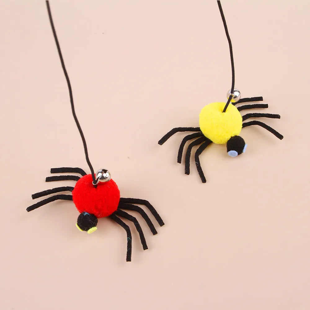 Red and yellow cat toy with feather and bell spider hanging from a door on an elastic rope.