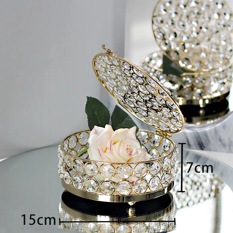 French gold iron jewellery box with a clear crystal glass lid on a wooden surface.