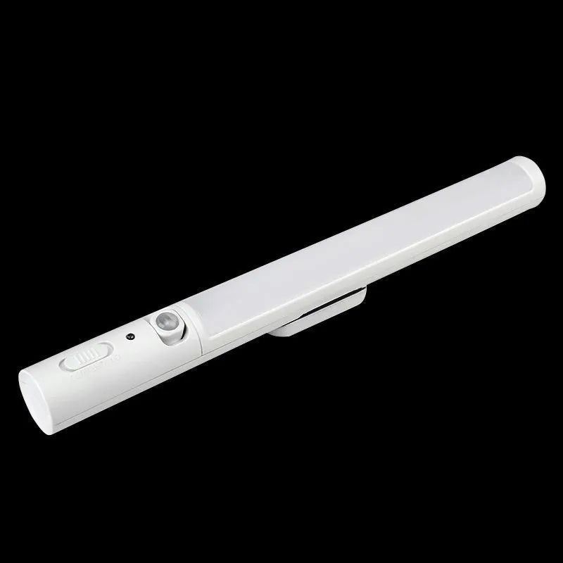Slim white human body induction LED cabinet light with magnetic base for sticking to metal surfaces.