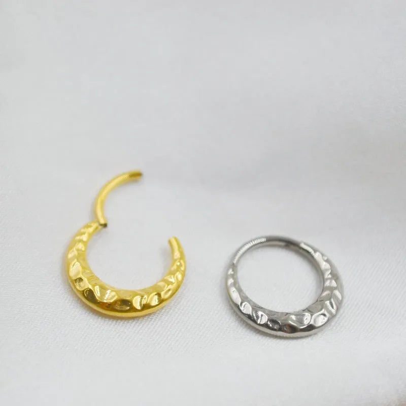 Close-up of a carved concave-convex titanium nose ring in silver finish