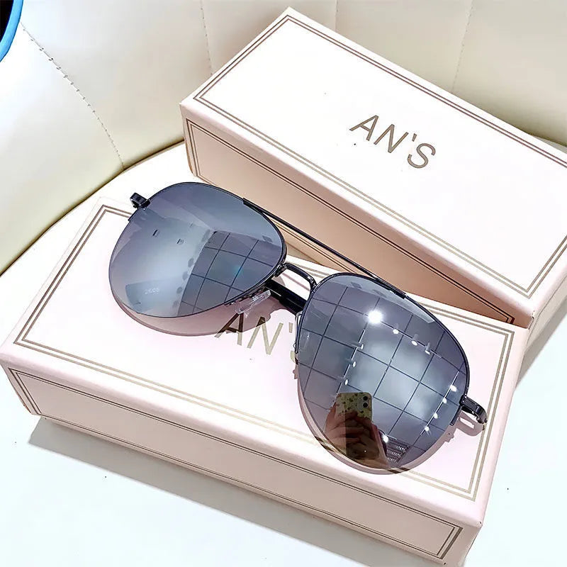 Aviator-style sunglasses with a metal frame and tinted resin lens, shown in a gold frame variant.