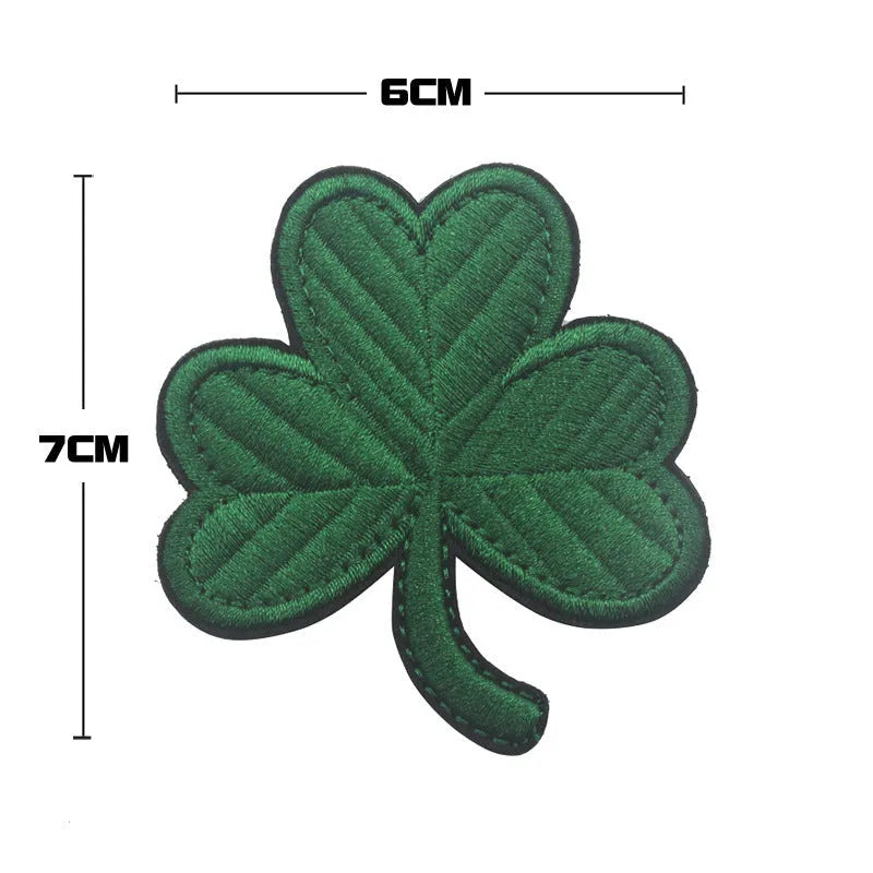 Outdoor embroidered fabric badge with green clover design on a velcro strip backing.
