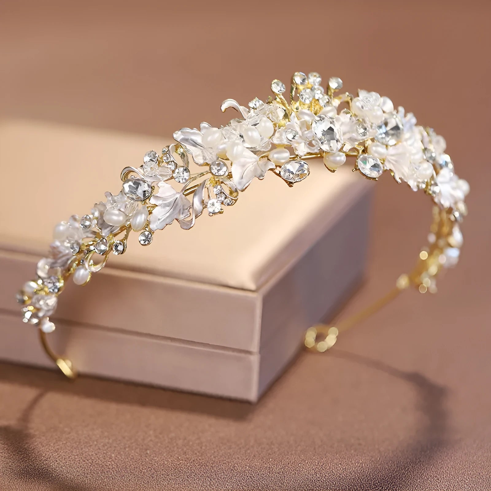 A gold-coloured alloy crown headdress for women with glass pearl decorations on a model's hair.