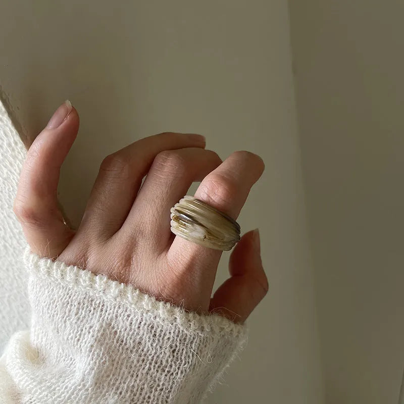 Chinese style irregular geometric resin ring in wide band design showing brown and white colour options