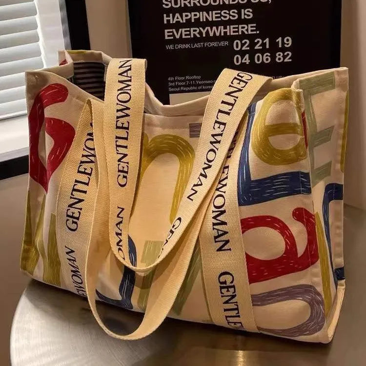 Women's large capacity canvas tote bag with printed design in three colour options.