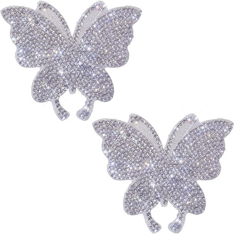 Close-up of a diamond-encrusted glass car sticker in a bear paw or butterfly design on a car surface.