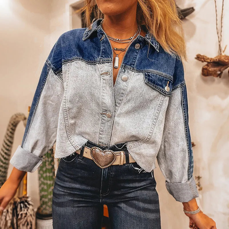 Women's loose blue denim coat with a row of silver buckle closures down the front.