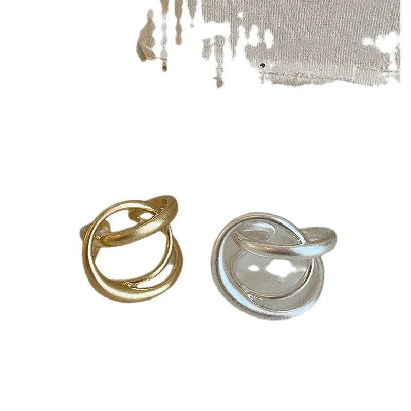 Geometric open ring for women with 3D interlaced matte metal design in gold and silver colour options.