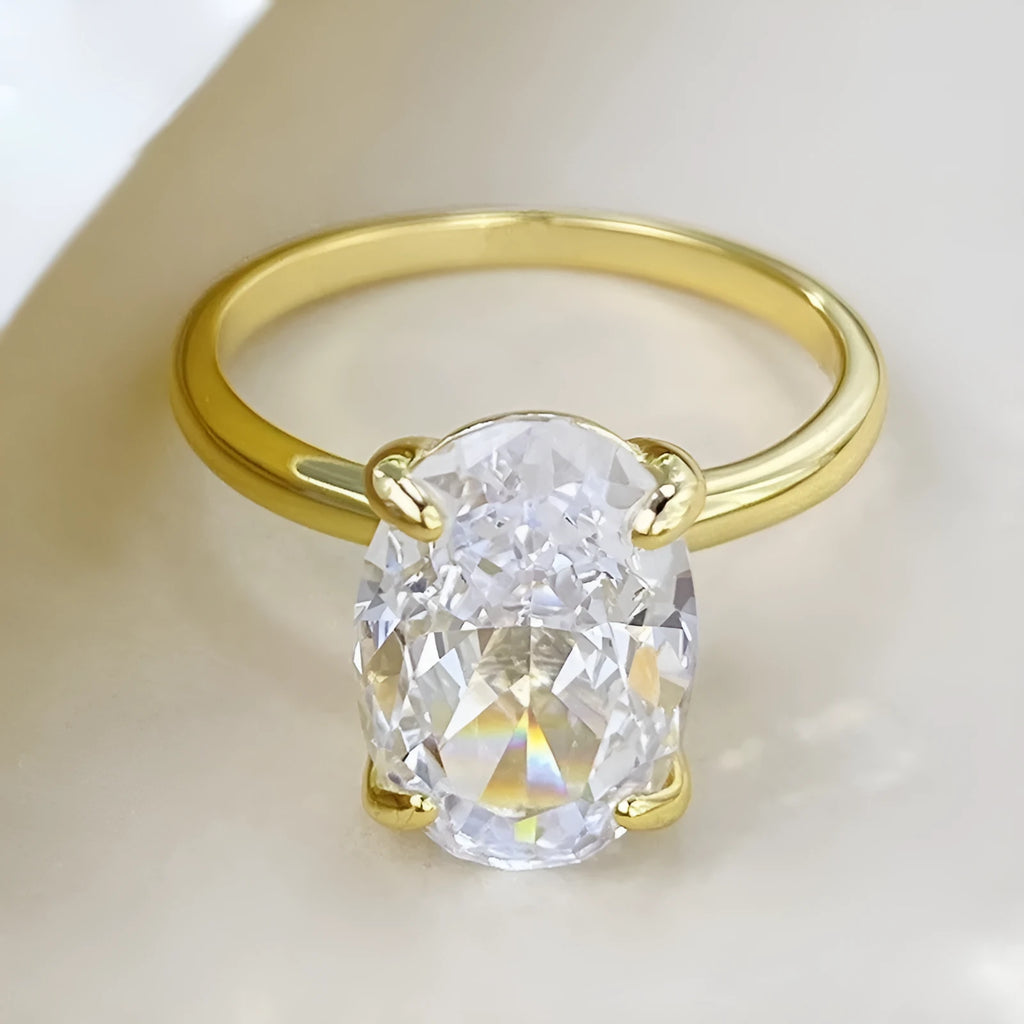 Women's oval silver ring with a four-claw setting holding a hand-cut gemstone.