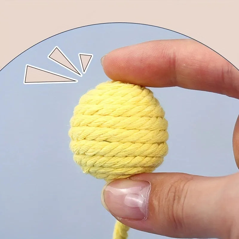 Cat toy ball with rope attached in green, pink, purple, or yellow colours with internal bell