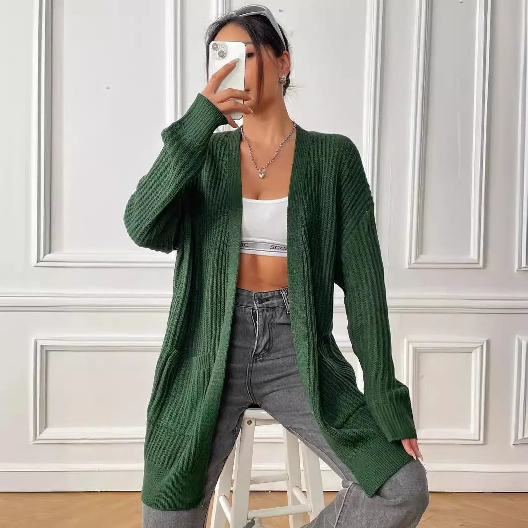 A loose-fitting, mid-length acrylic cardigan sweater in a solid colour, shown in a street hipster style.