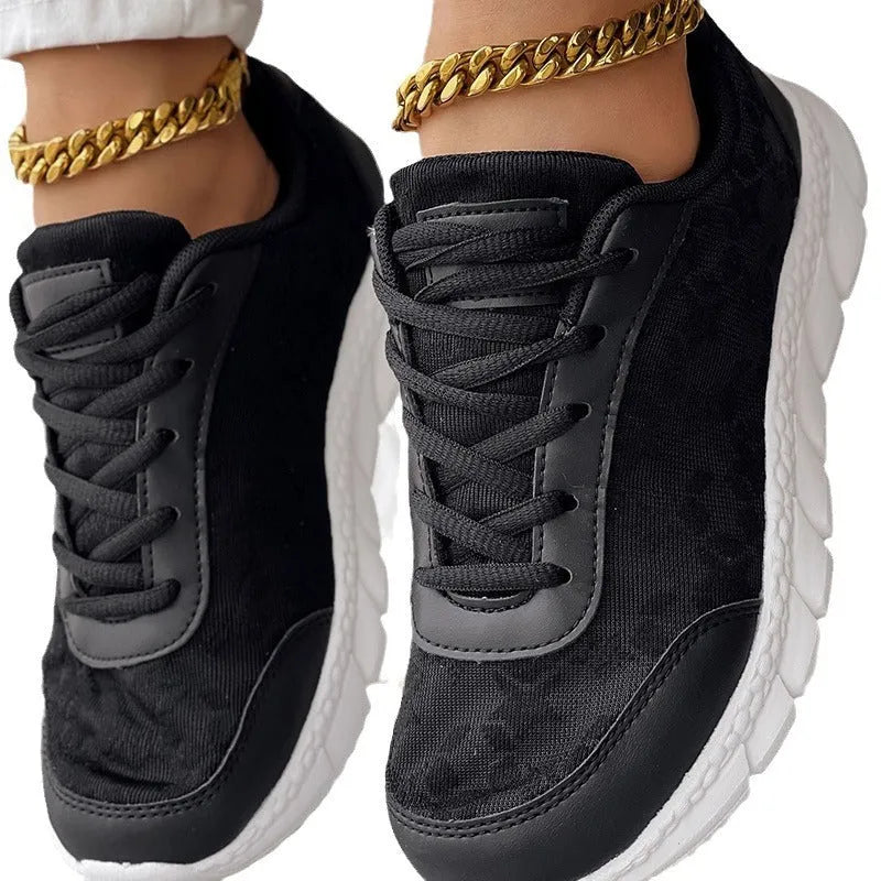Women's white canvas flat heel running shoe with round toe on a solid background