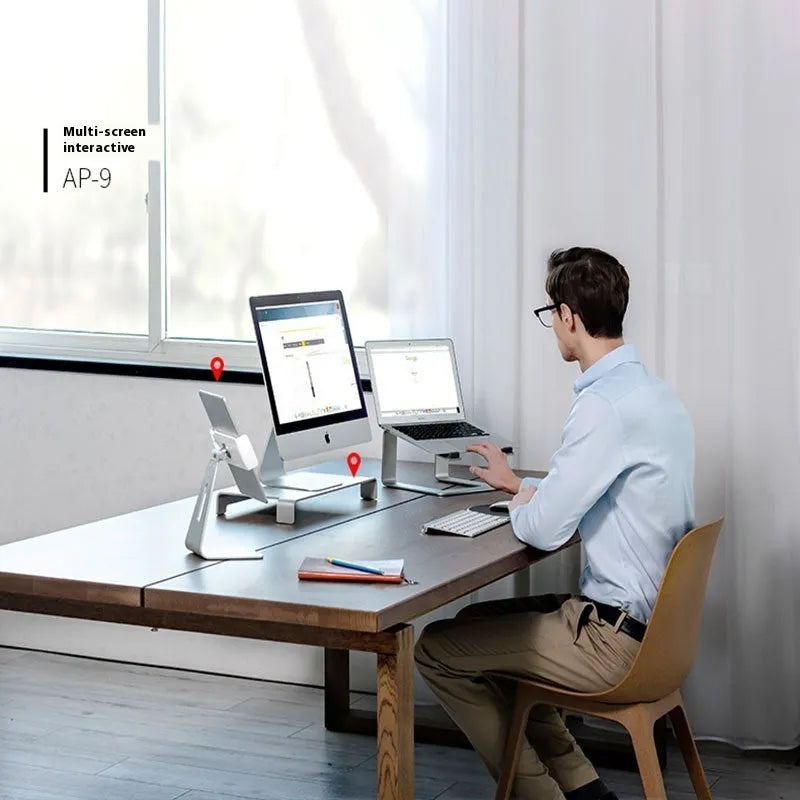 Black aluminium alloy laptop stand on a desk, showing its wide base plate and elevated height.