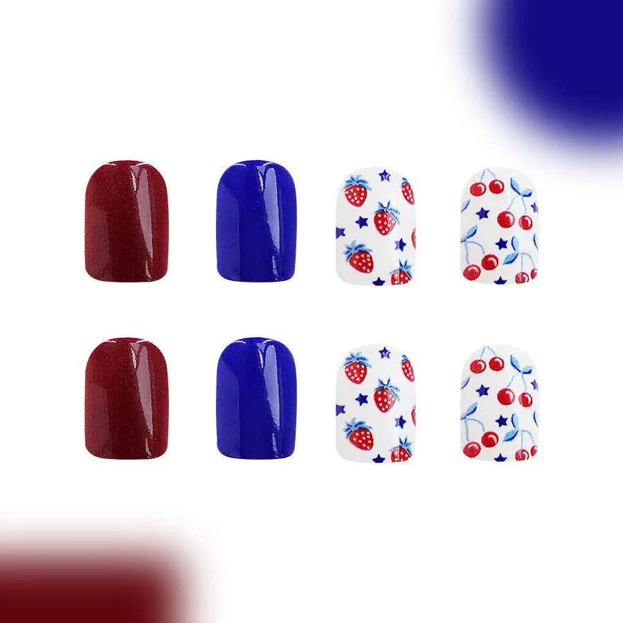 Short glossy false nails with strawberry and cherry patterns in red and blue colour combinations
