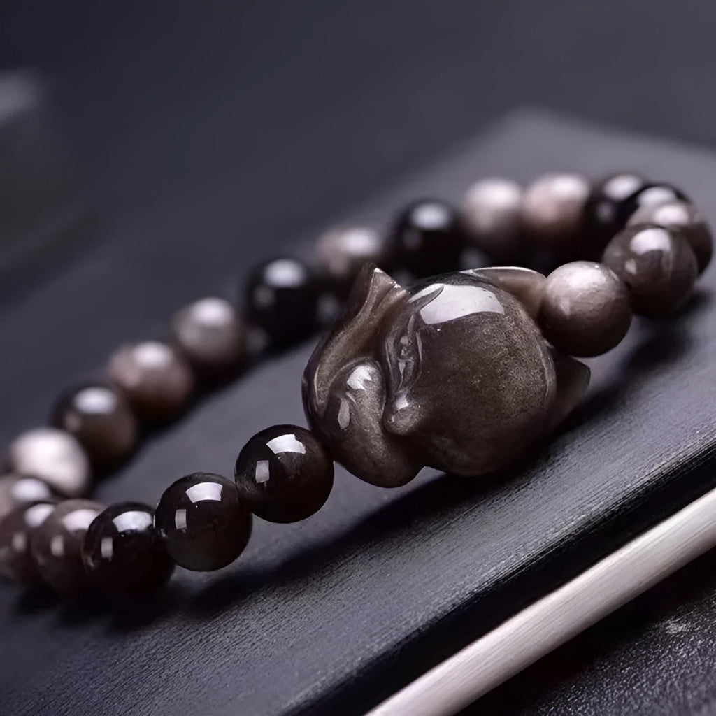 Obsidian fox charm bracelet for women showing a single black polished 8mm stone carved into a fox design.
