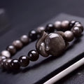 Obsidian fox charm bracelet for women showing a single black polished 8mm stone carved into a fox design.