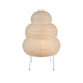 Nordic style table lamp with a handmade Japanese rice paper shade and aluminium base on a wooden table.