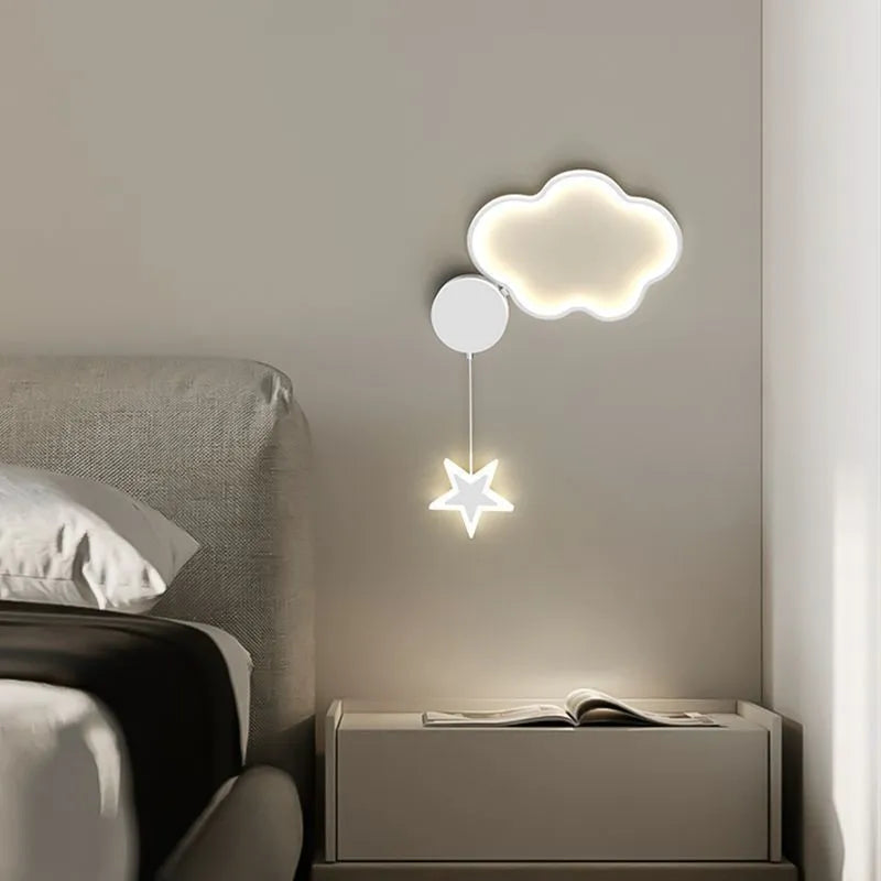 White cloud-shaped children's wall lamp with 3-colour LED light mounted beside a bed.