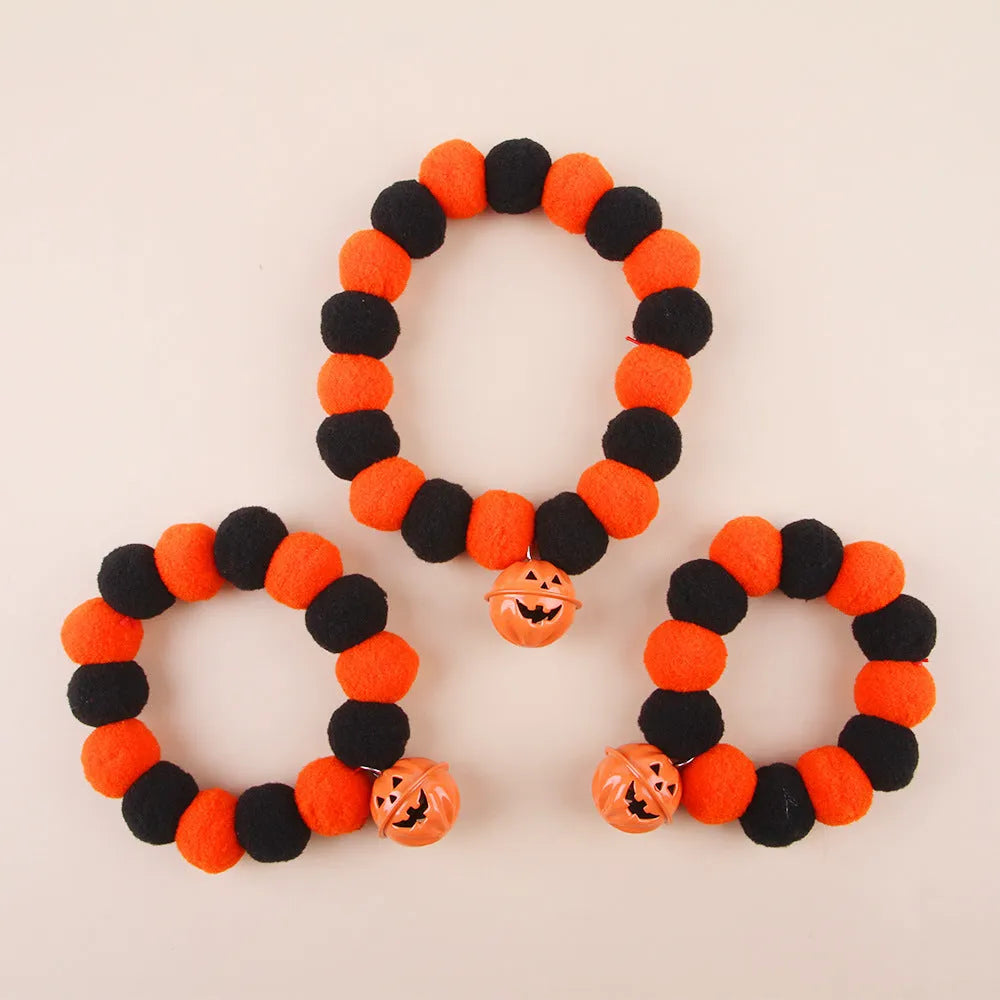 Halloween pet collar with orange pumpkin charm on black and white patterned nylon strap.