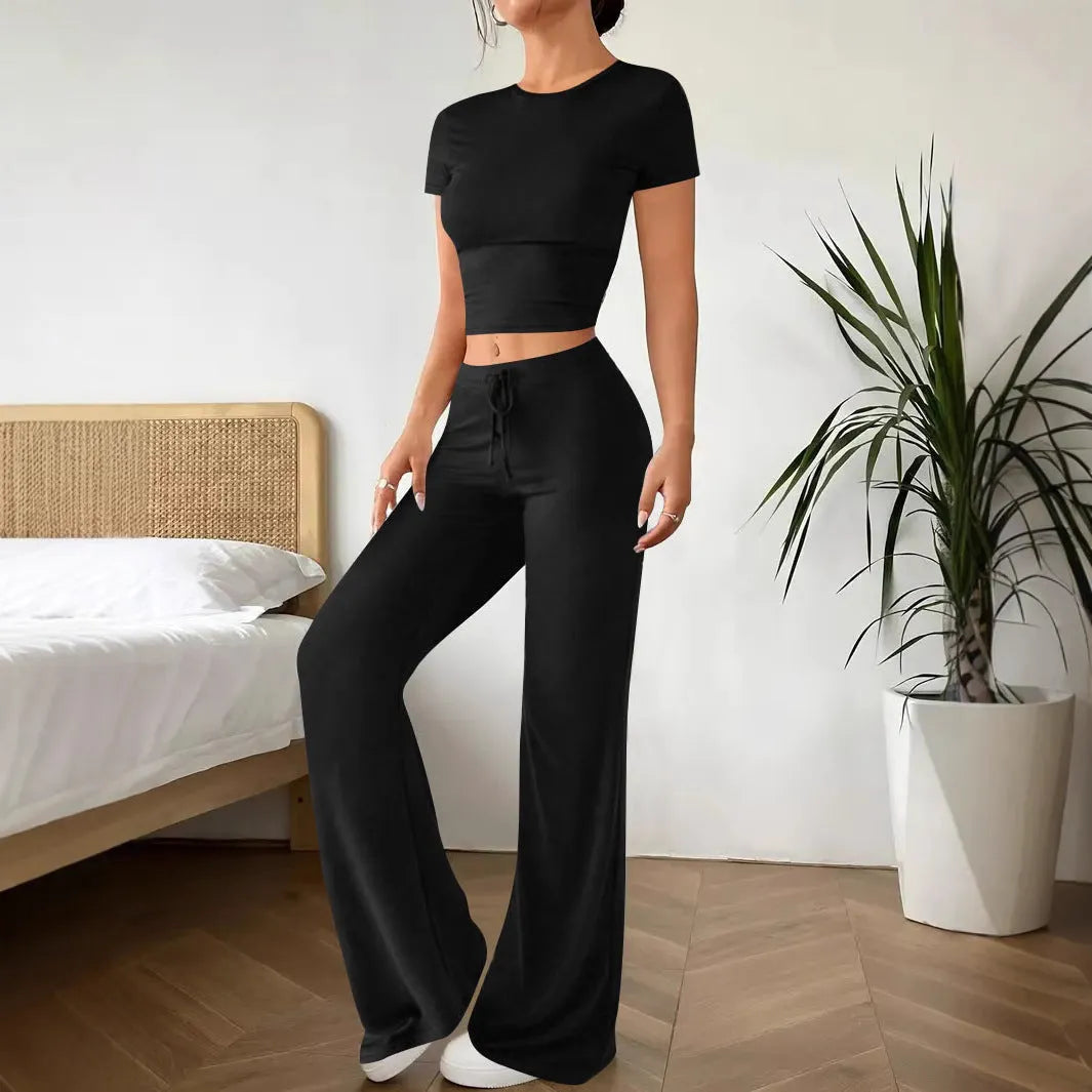 Black high-waist trousers and short-sleeve T-shirt co-ord set laid flat.