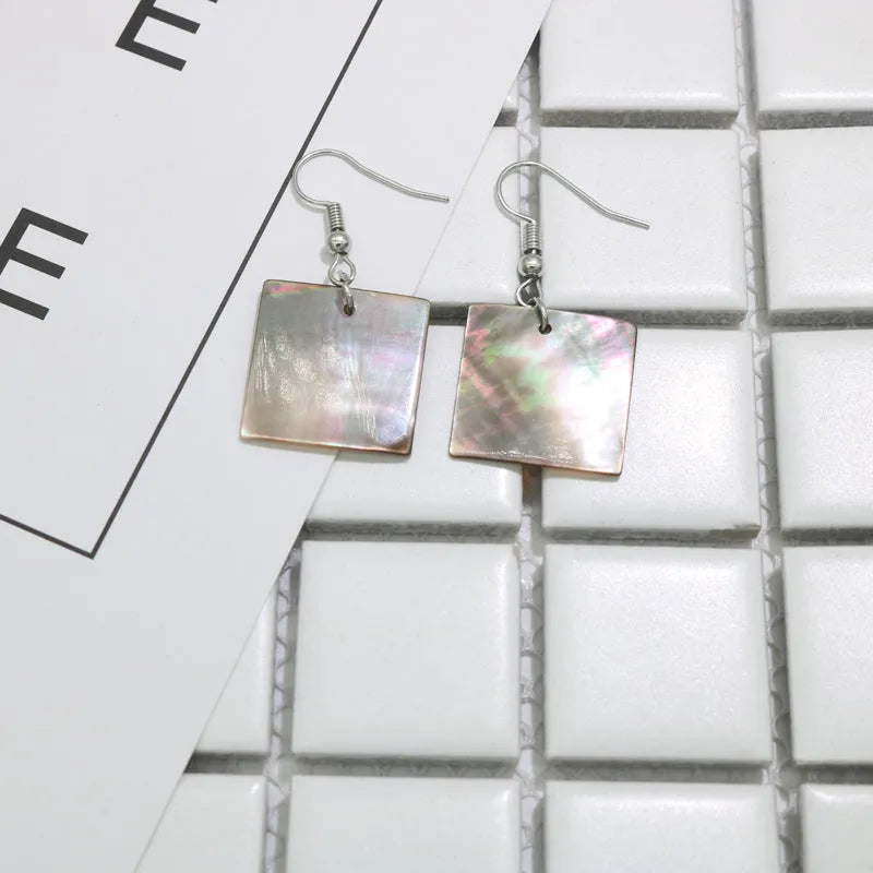 Geometric shell earrings in square panther or rectangular shell styles with natural material texture