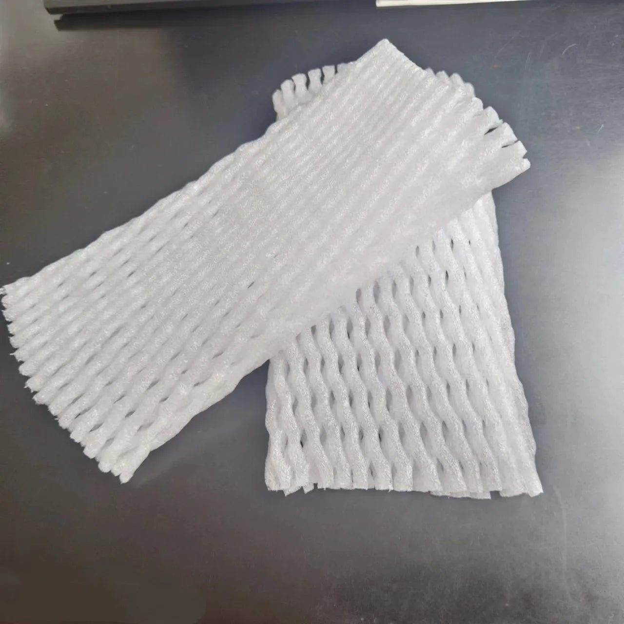 White foam net protective sleeve for apples and oranges, shown in various sizes.
