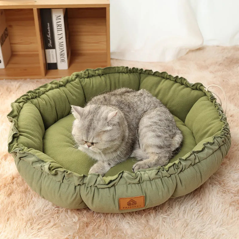 Grey reversible donut-shaped cat bed for indoor pets on a wooden floor.