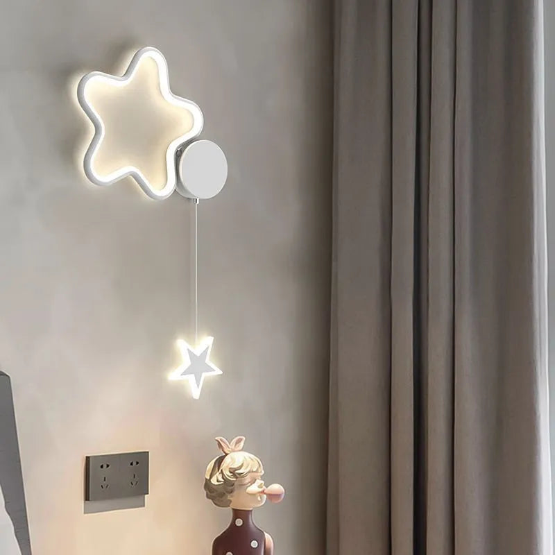 White cloud-shaped children's wall lamp with 3-colour LED light mounted beside a bed.