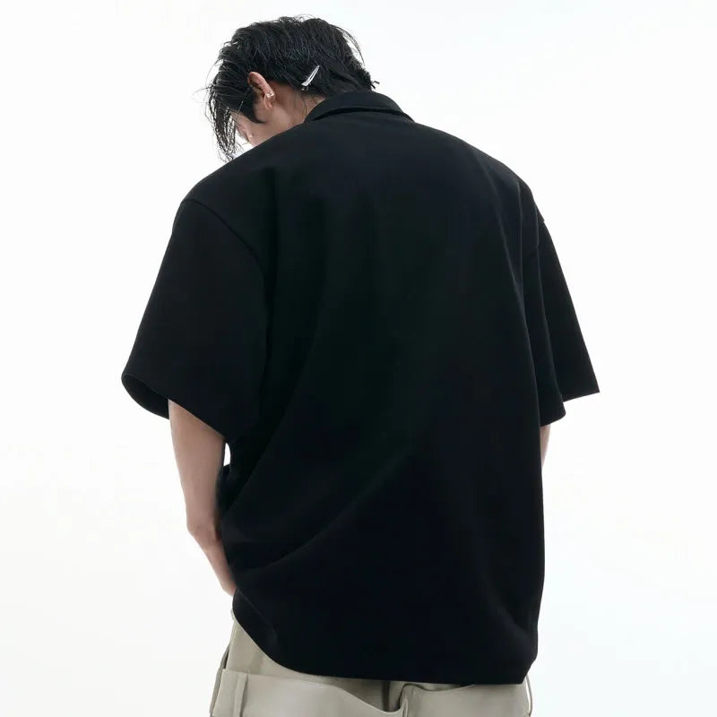 Men's black loose-fit polo shirt with a deconstructed multi-collar and geometric chest pattern.
