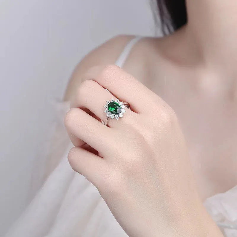 Women's copper flower ring with moissanite inlay in sapphire blue, red, or green on a model's hand.