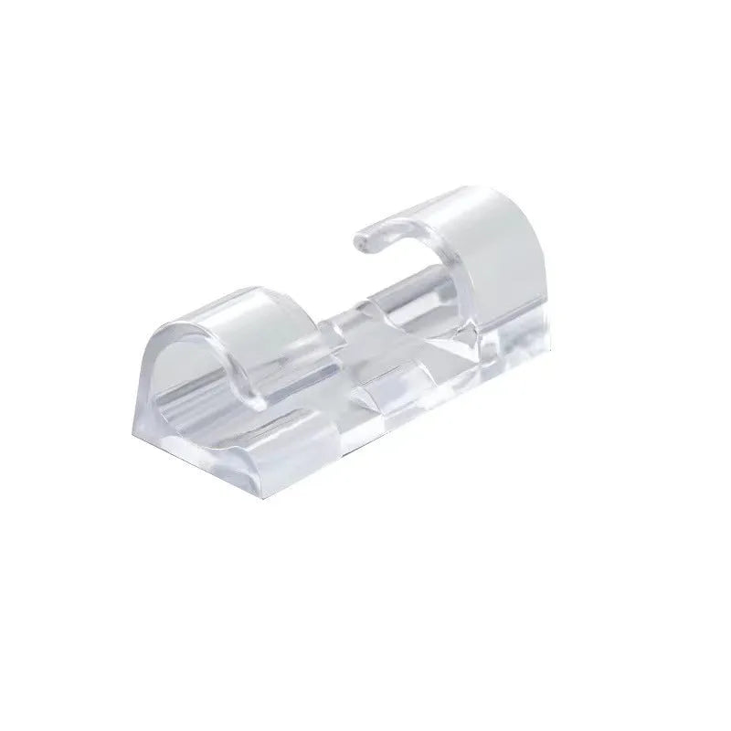 Transparent self-adhesive plastic wire holder snap clips for cable management on a white surface.