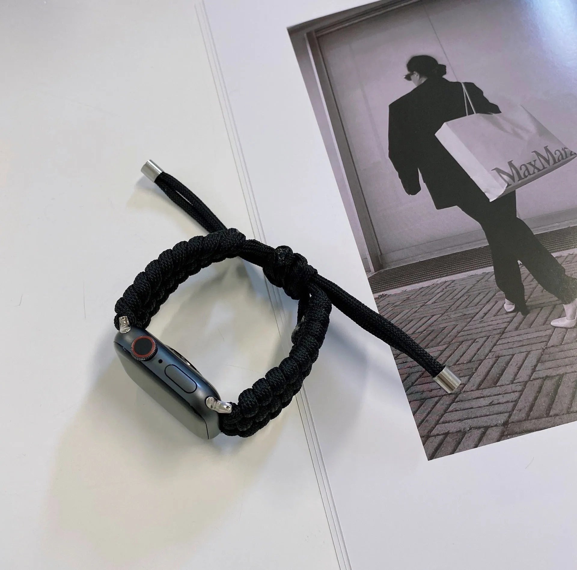 Paracord braided smart watch strap in black on a watch, showing woven texture and metal connectors.
