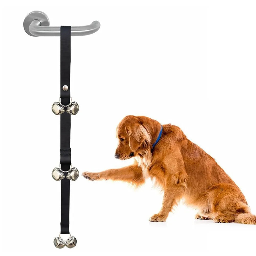 Set of six silver metal dog training bells on an adjustable black nylon leash hung on a door