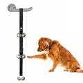 Set of six silver metal dog training bells on an adjustable black nylon leash hung on a door