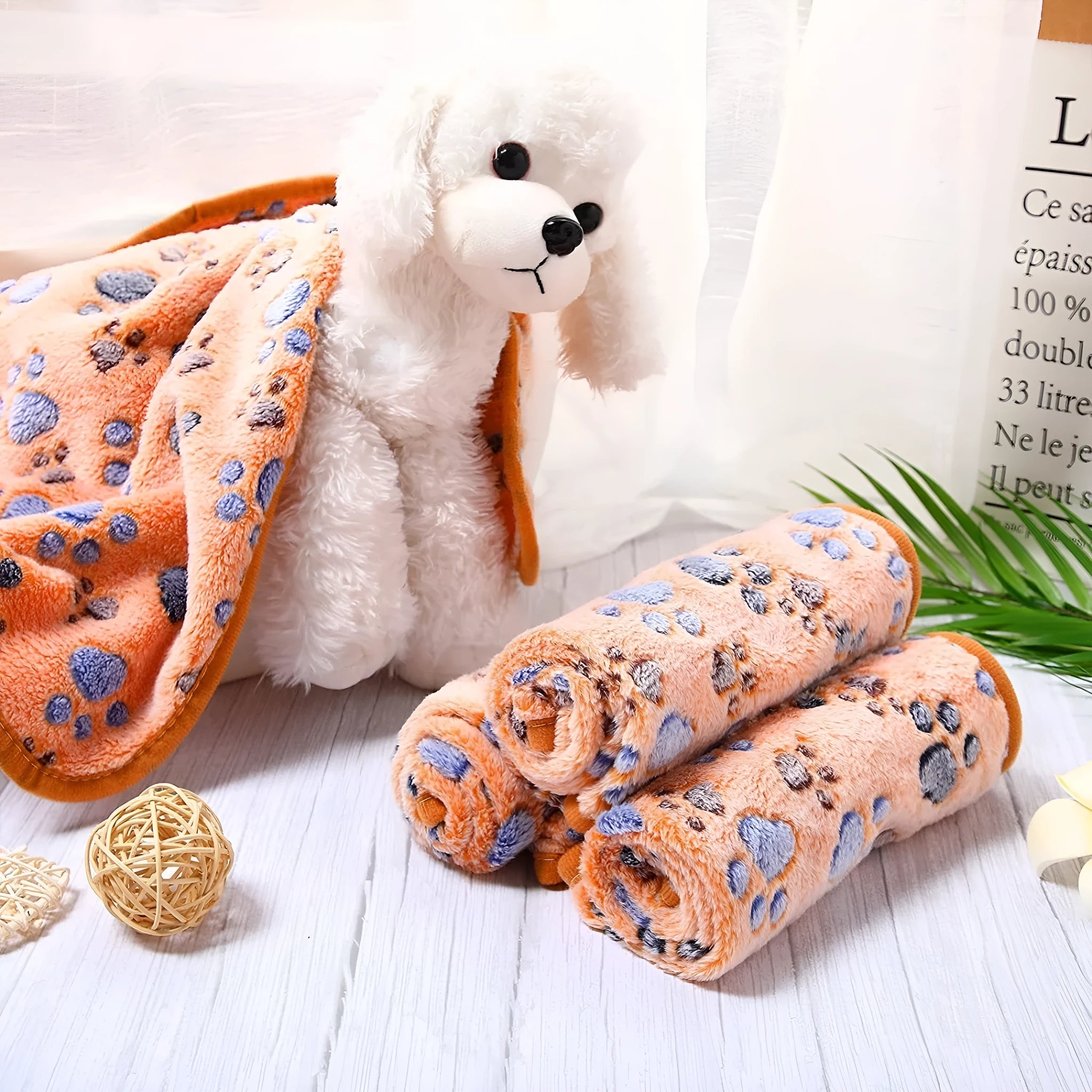 Coral fleece pet blanket with dog paw print pattern in beige, shown alongside size options from small to extra large.