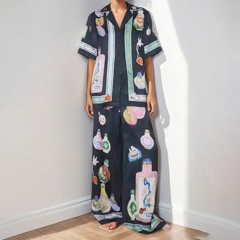 Black women's casual set with cartoon pattern, featuring a short sleeve cardigan and matching trousers.