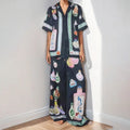 Black women's casual set with cartoon pattern, featuring a short sleeve cardigan and matching trousers.