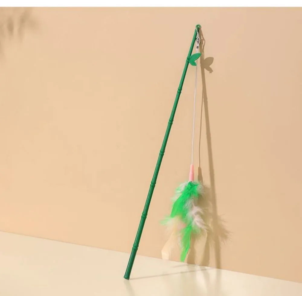 Green interactive cat feather wand toy with bells attached for indoor play and training