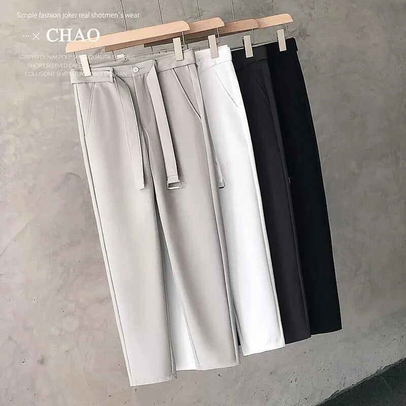 Boy wearing slim straight wool trousers in a neutral colour, showing tapered leg and straight hem.