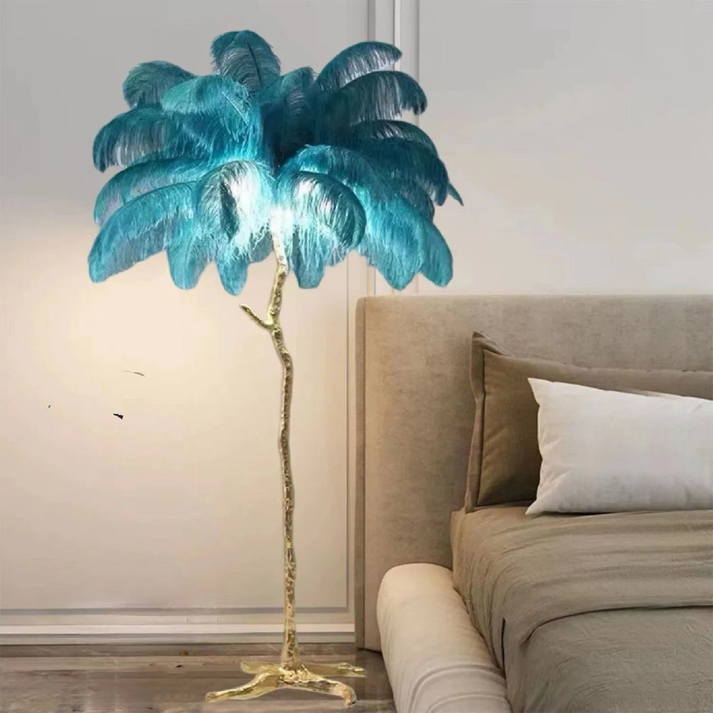 Tall decorative floor lamp with many white resin feathers and a dark base on a wooden floor.