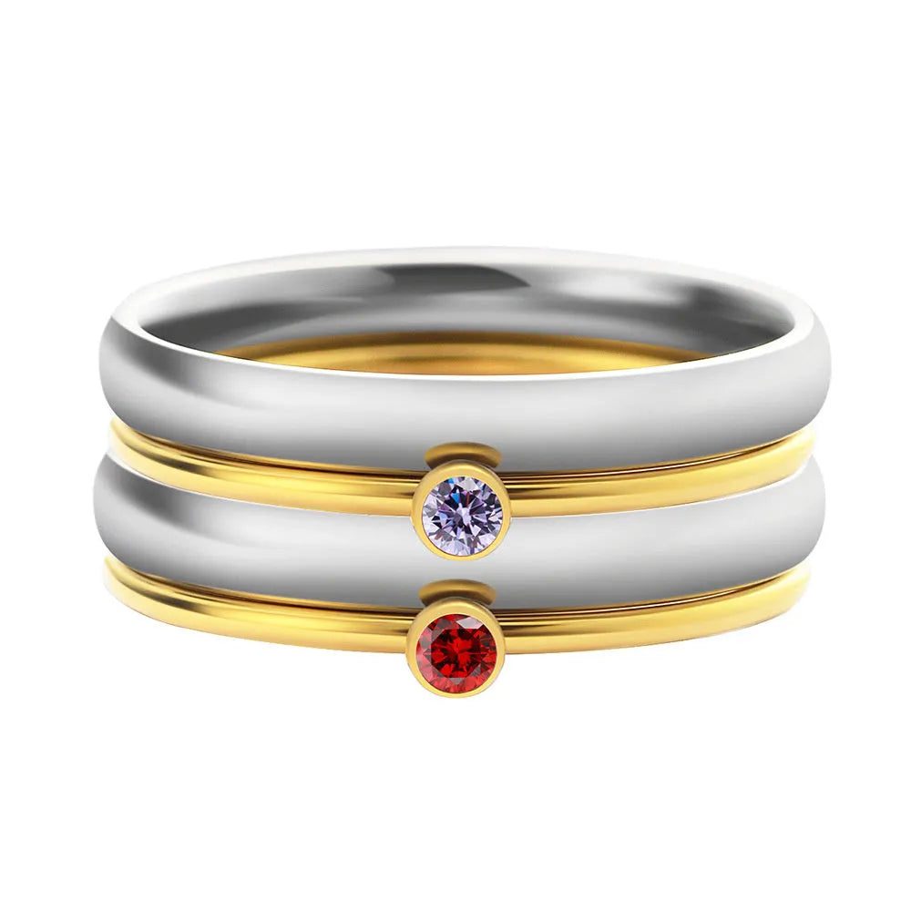 Gold tone titanium steel ring with a blue December birthstone and engraved geometric band.